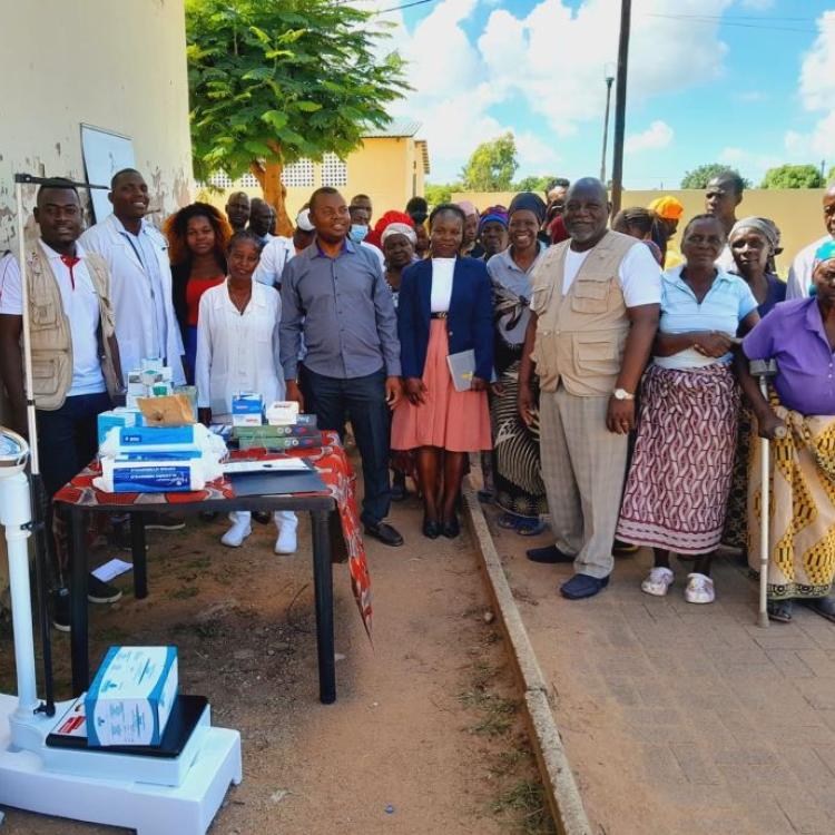 Grupo de voluntarios e idosos pousando para foto com as doacoes de medicamentos